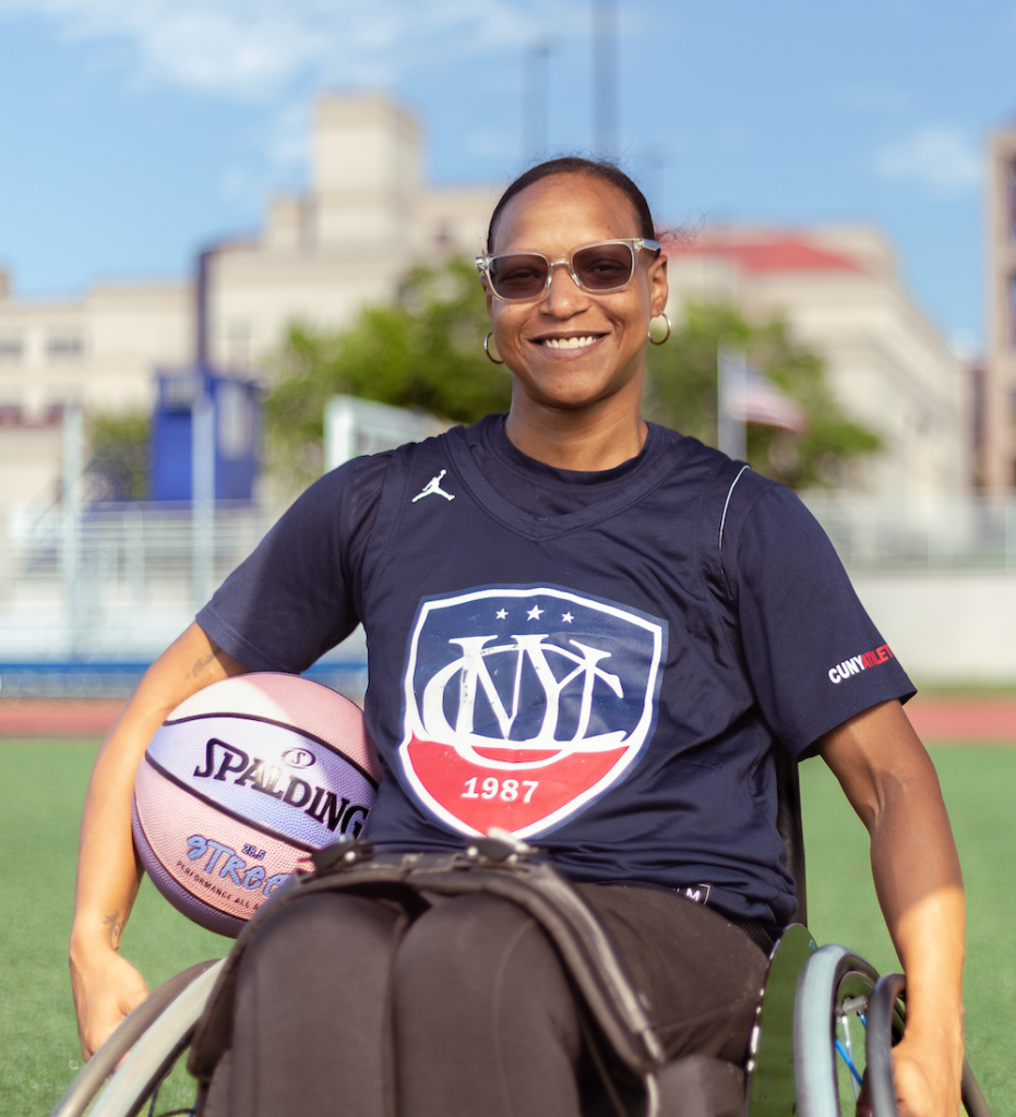 Gesy Duran sitting in a wheelchair and holding a basketball.