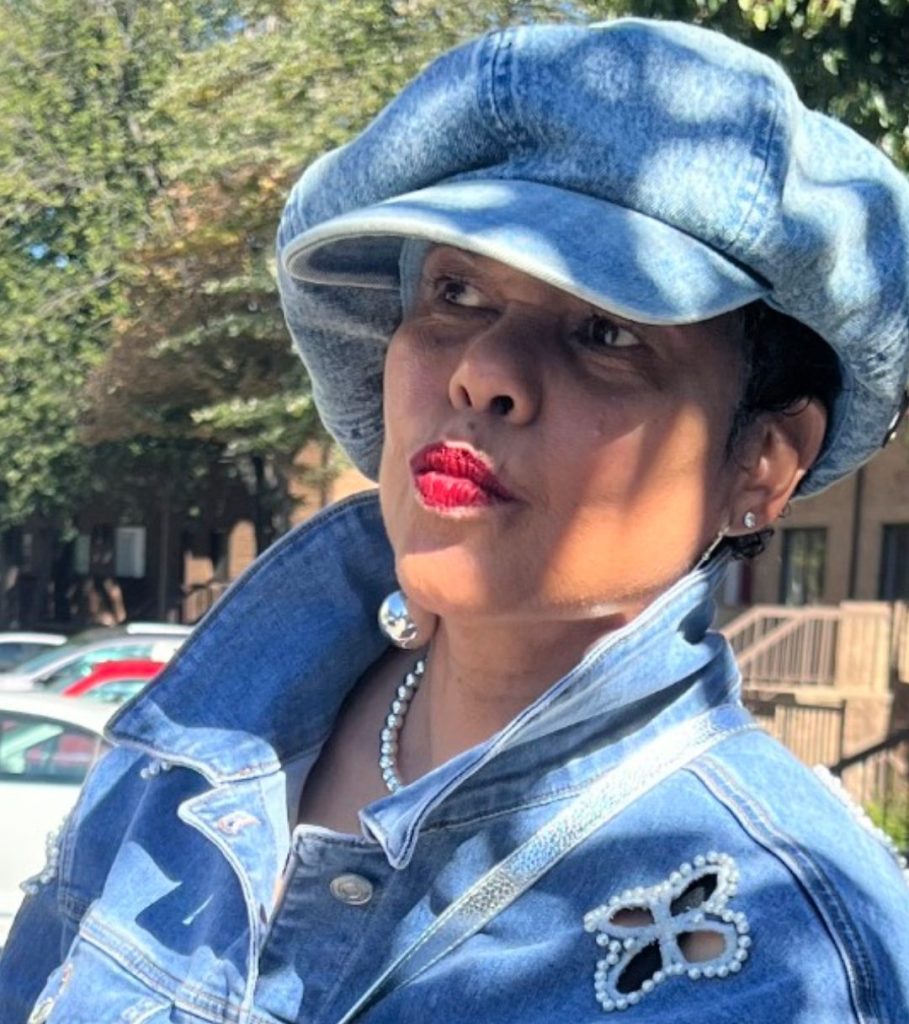 A photograph of Donna Walton wearing a denim outfit and denim cap.